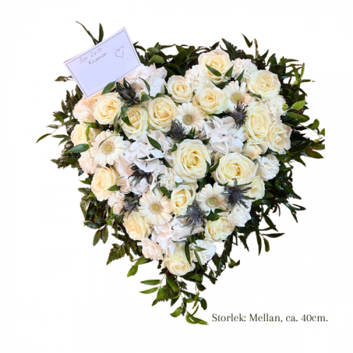 Begravningshjärta i storlek mellan. Hjärtat är gjord med mixade blommor i vita toner.